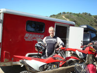 a man standing next to a red motorcycle